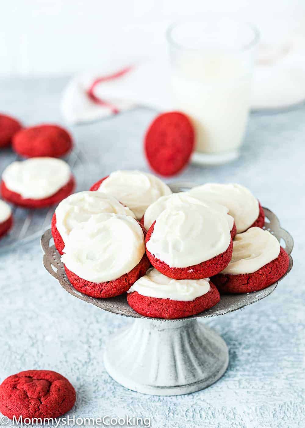 egg free red velvet cookies on a cake stand over a blue surface. 