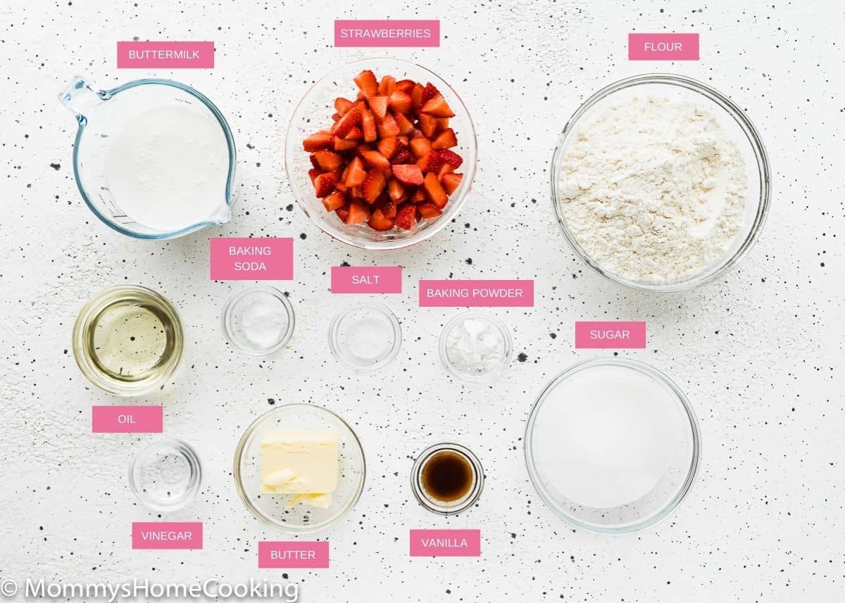 eggless strawberry muffins ingredients over a white surface with name tags.