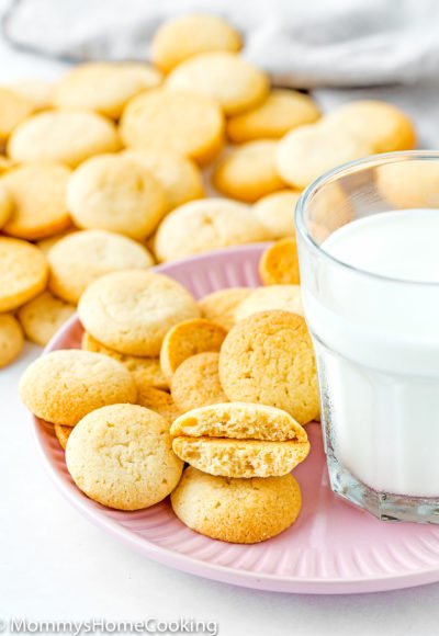 Eggless Vanilla Wafers (Nila Wafers) on a pink plate with a glass of milk on the side.