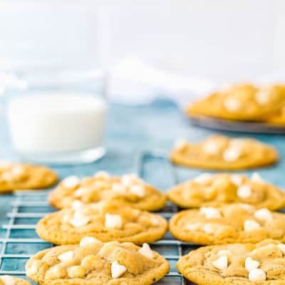 Eggless White Chocolate Cookie over a cooling rack with white chip on the sides