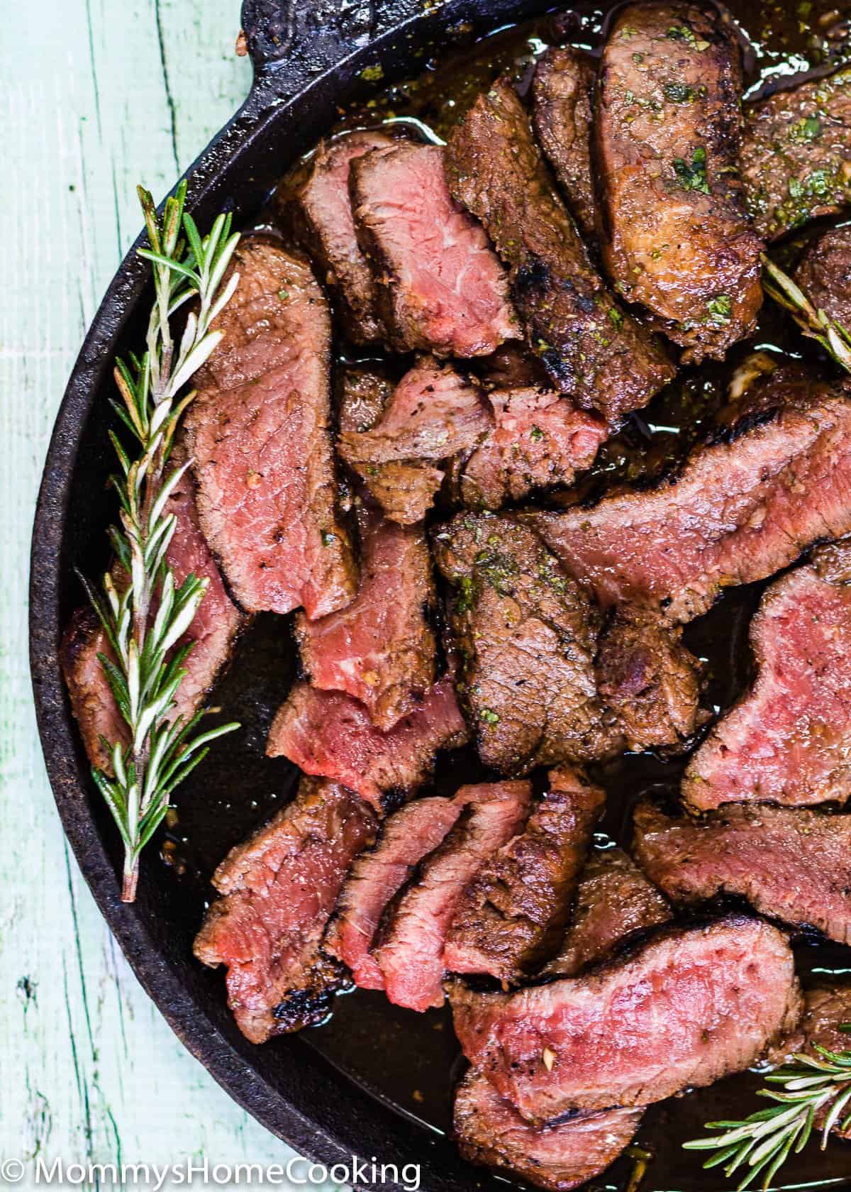 close up of GRILLED BALSAMIC-GARLIC STEAK on a cast iron skillet