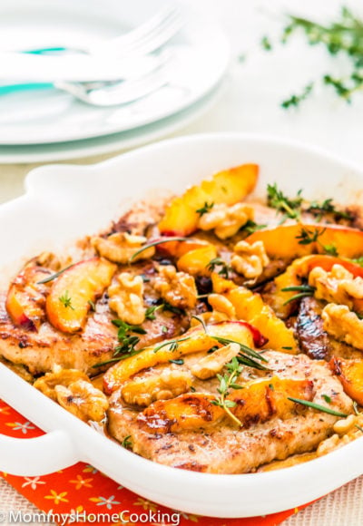 grilled pork chops and peaches with herbs in a skillet