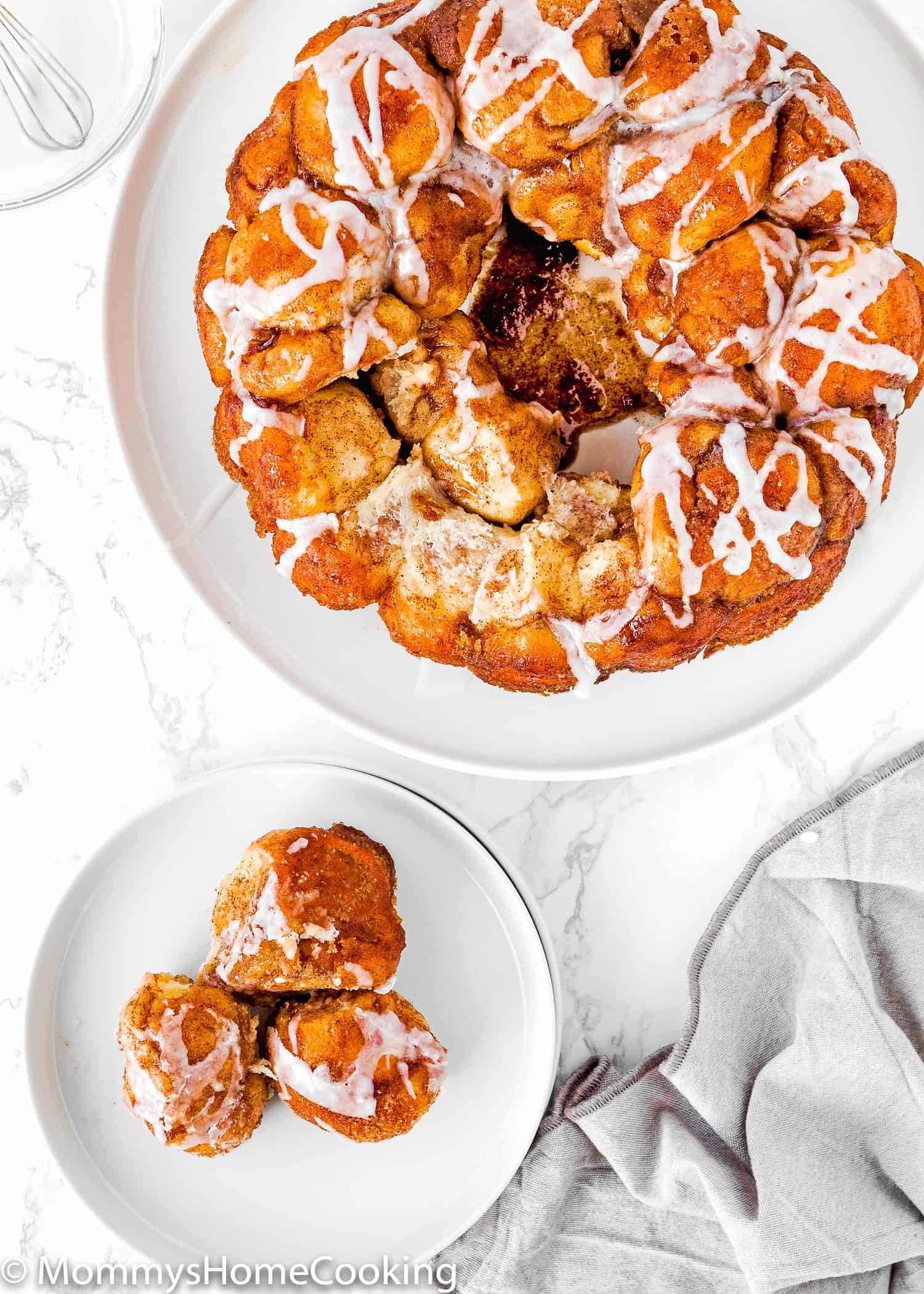 Homemade Eggless Monkey Bread on plates over a marble surface with kitchen table on the side. 