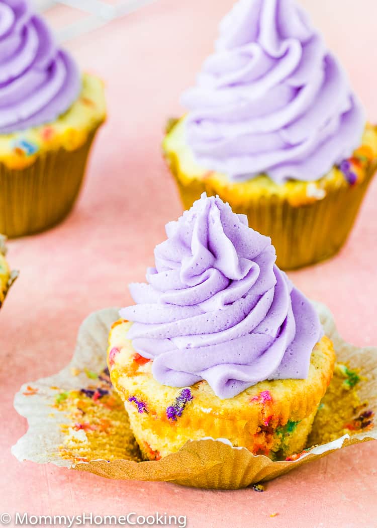 an eggless confetti cupcake with purple buttercream on top. 