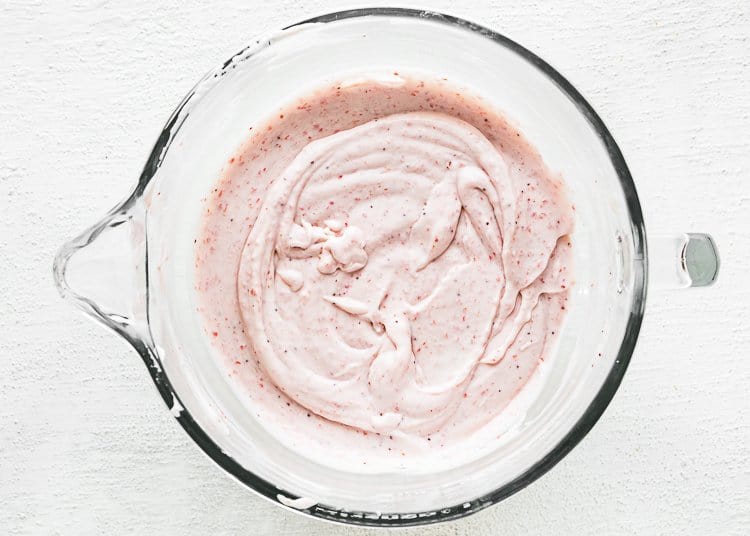 cream cheese, sour cream, sweetened condensed milk and strawberry puree  in a stand mixer bowl. 