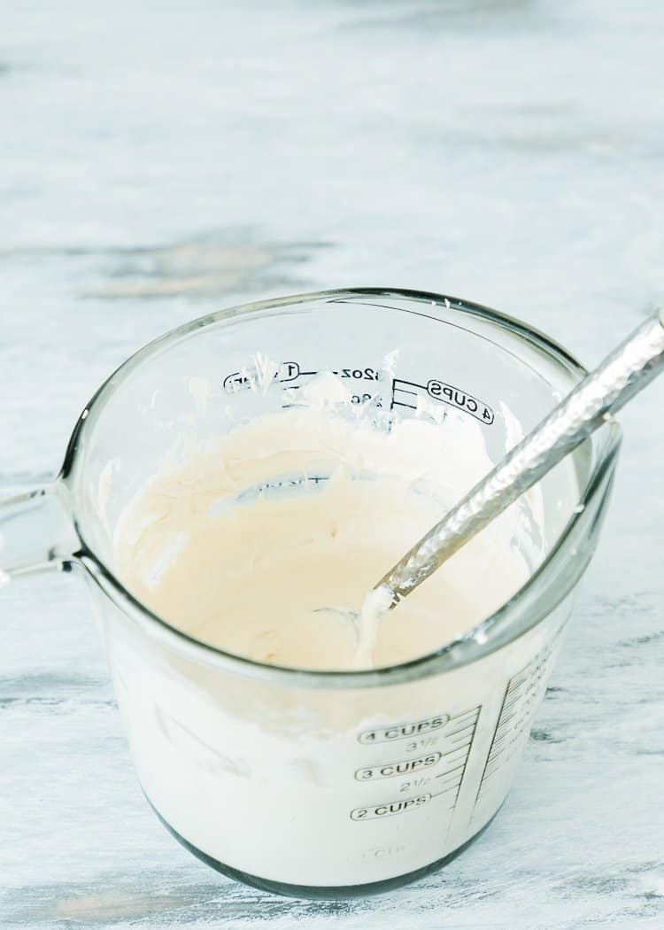 melted candy melts in a measuring cup with a spoon. 