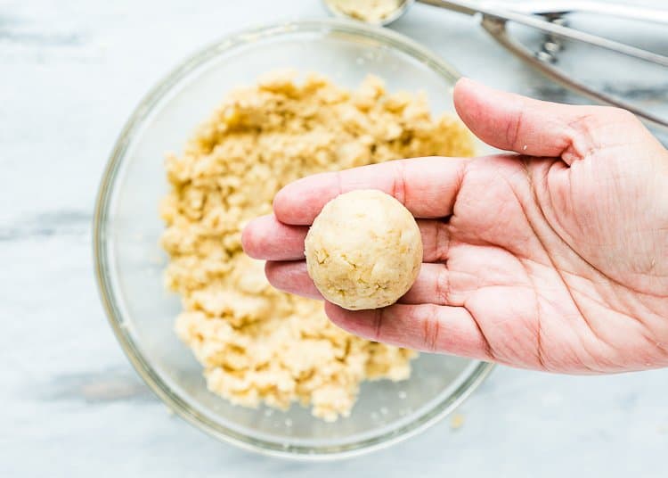 a hand holding an Eggless Homemade Cake pop ball.