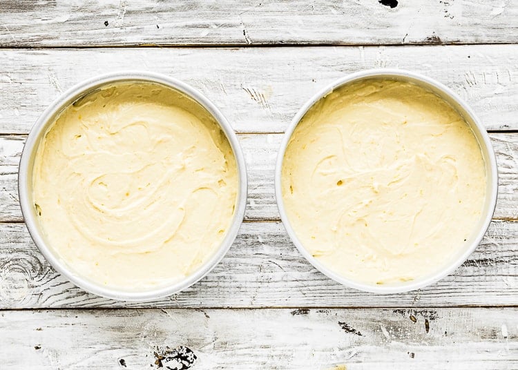 two round cake pans with eggless orange cake batter.