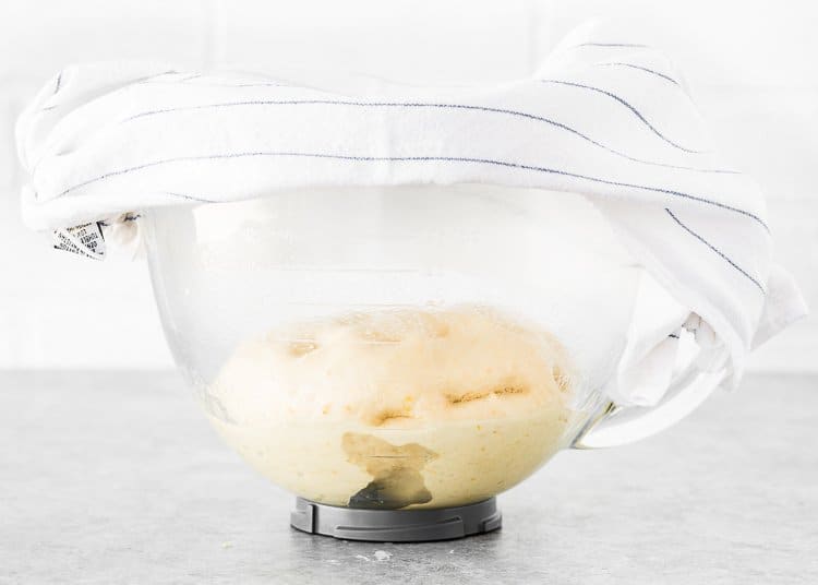 egg-free Hawaiian rolls dough in a stand mixer bowl cover with a kitchen towel. 