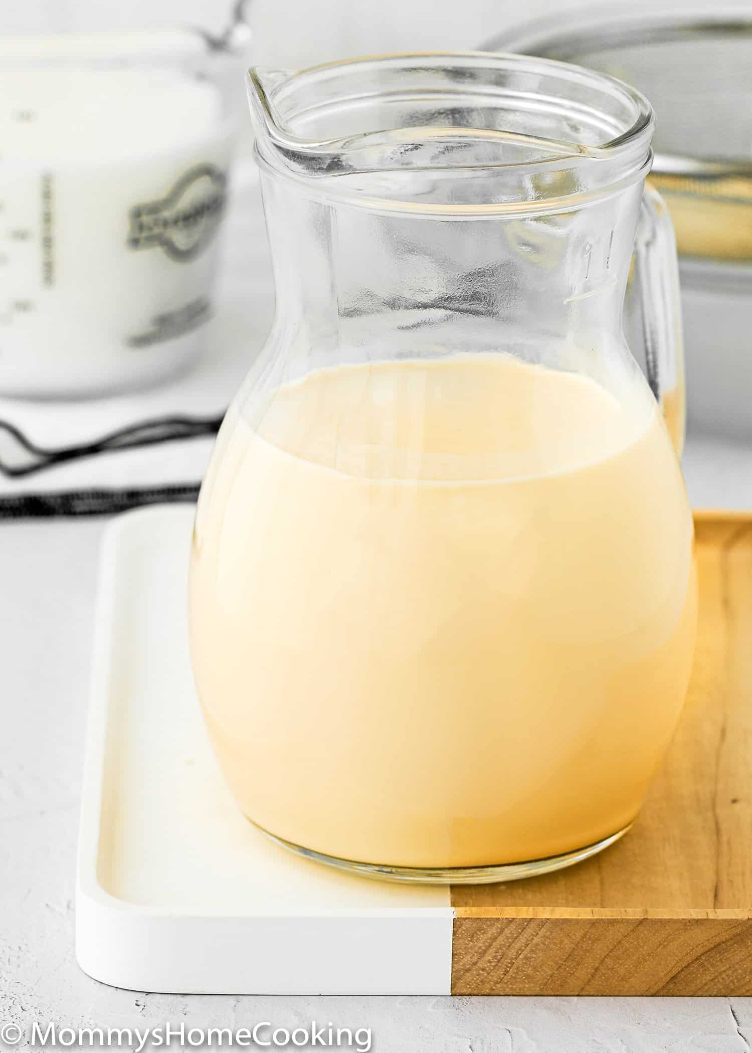 Homemade evaporated milk in a glass container.