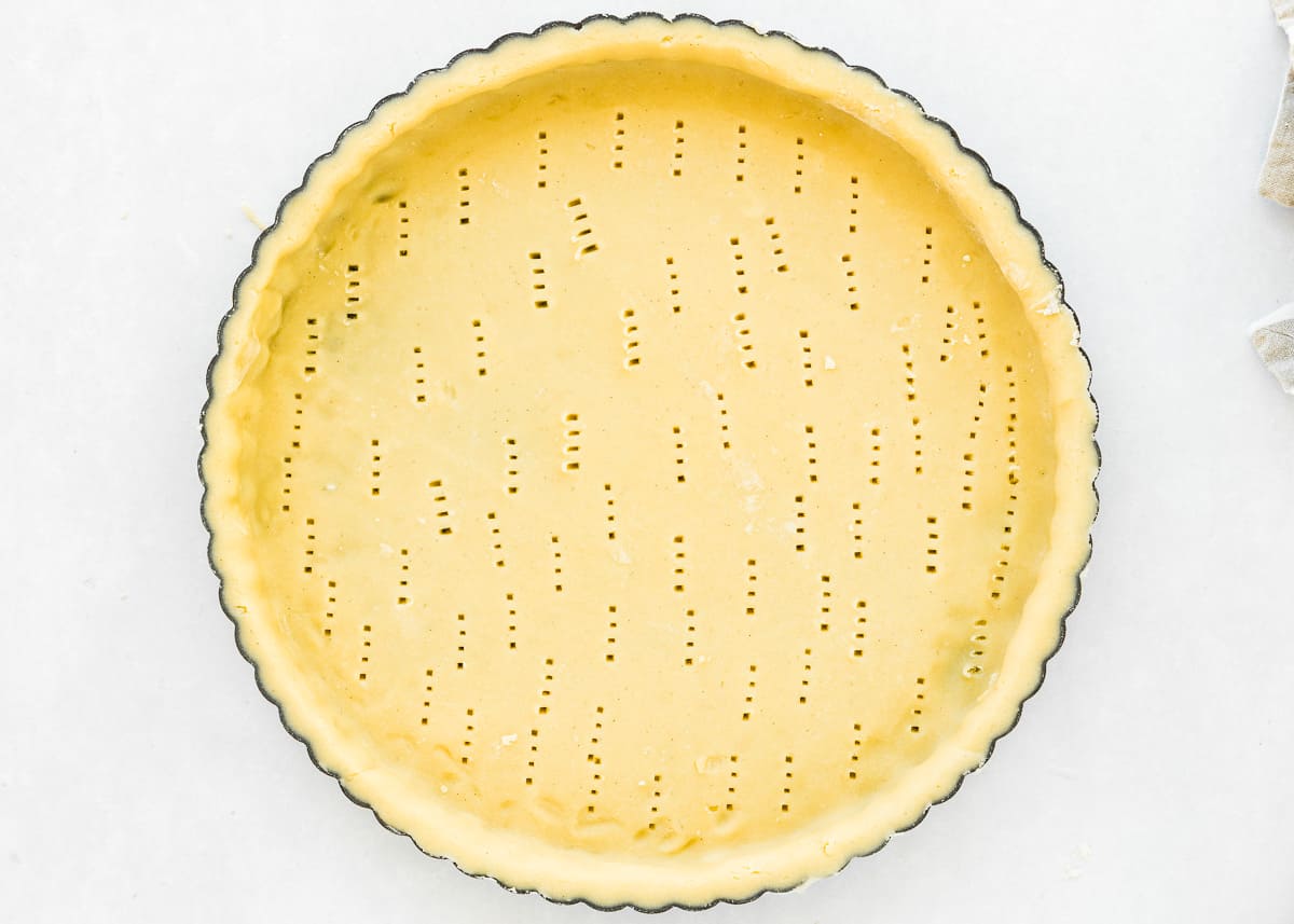 pricked and pressed eggless tart dough into a tart pan.
