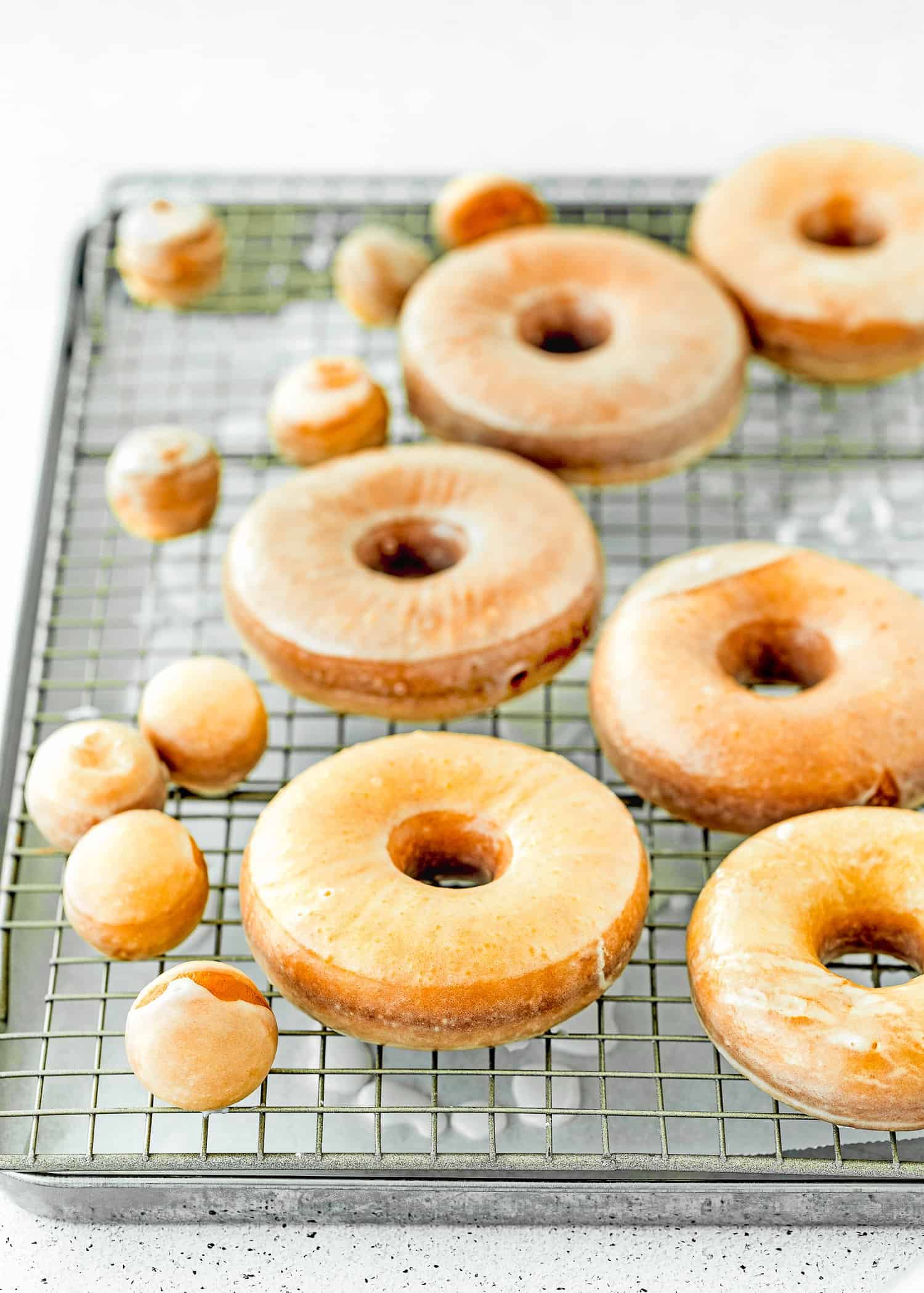 glazed eggless donuts over a cooling rack. 