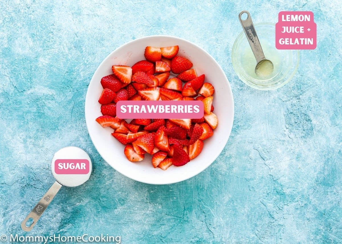 ingredients needed to make homemade strawberry sauce at home over a blue surface.