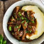 Beef Tips with Gravy and mashed potatoes in a bowl