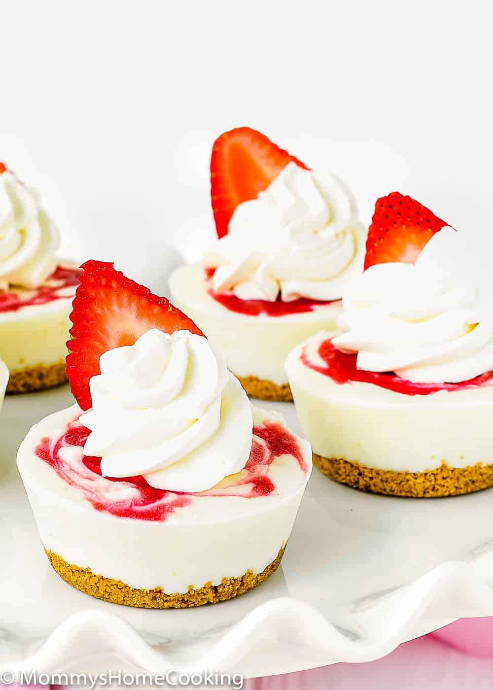 Mini Greek Yogurt Strawberry Cheesecakes with whipped cream.