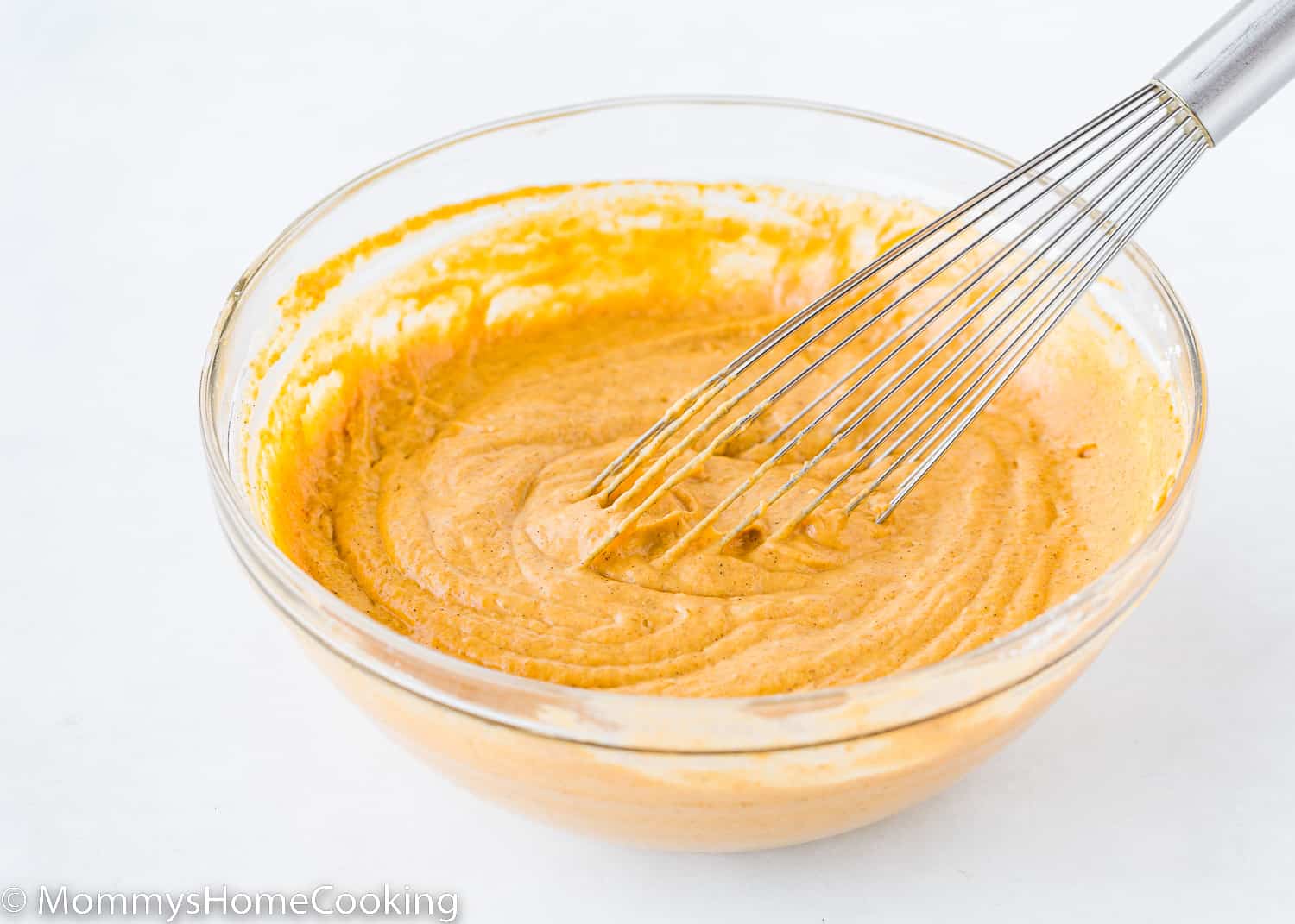 eggless pumpkin waffles batter in a bowl with a whisk.