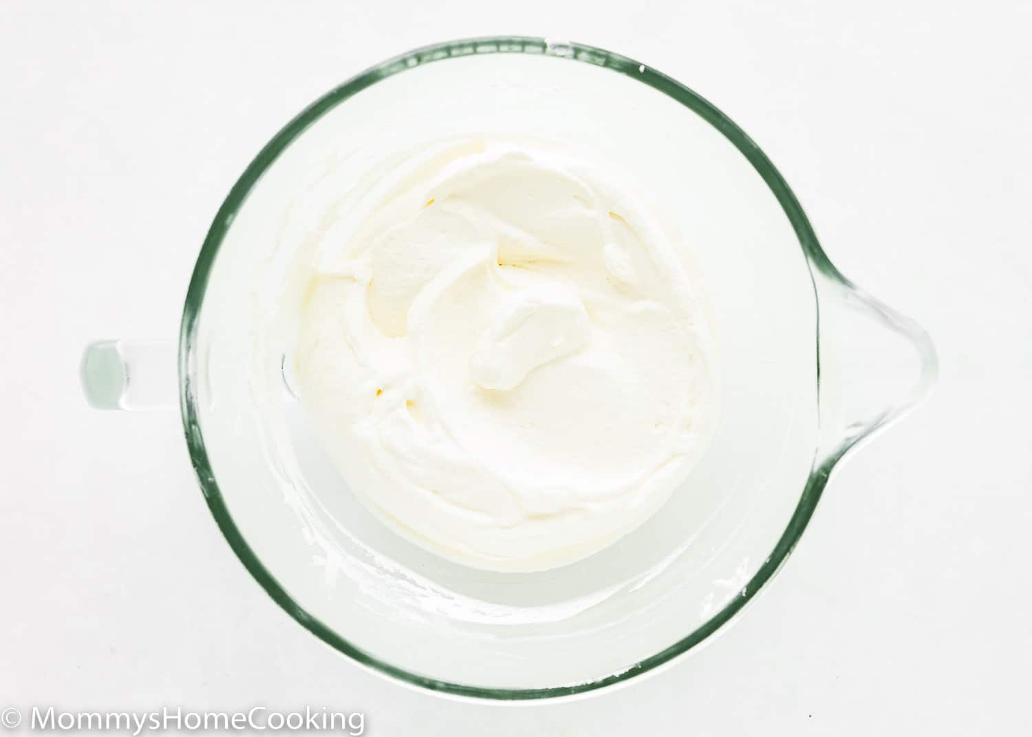 Whipped cream in a stand mixer bowl.