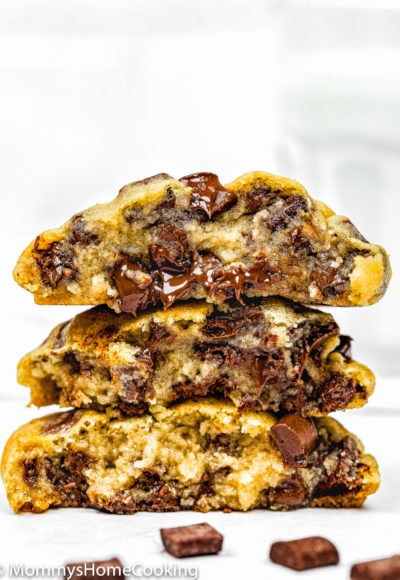 three egg-free chocolate chip cookies cut in half showing its chewy and gooey inside texture.