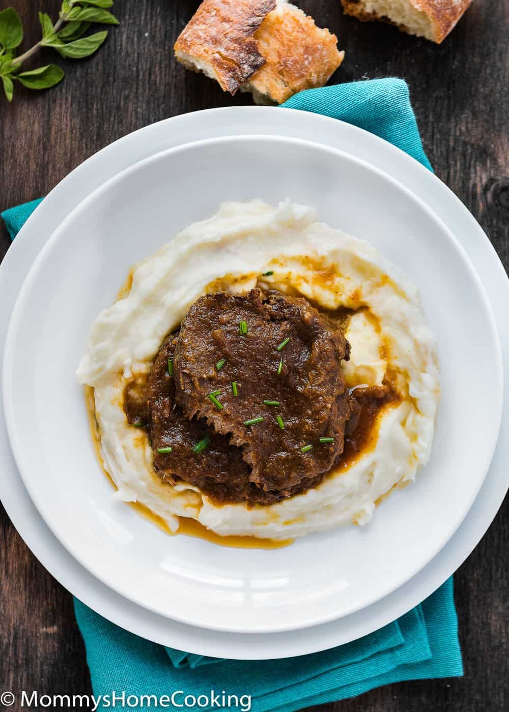 Venezuelan Asado Negro in a white plate with mashed potatoes and sauce