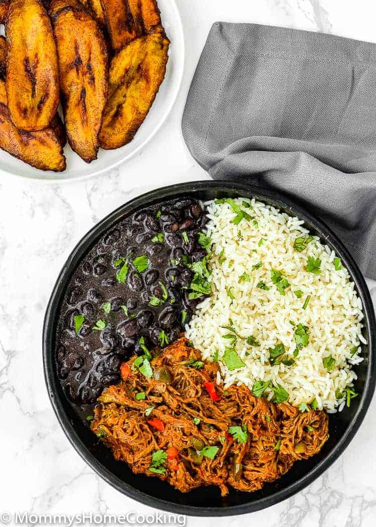 This Venezuelan Pabellon Bowl is meal perfection! Shredded beef, black beans, white rice and fried plantains, make this dish a hearty, filling and most delicious lunch or dinner ever. https://mommyshomecooking.com